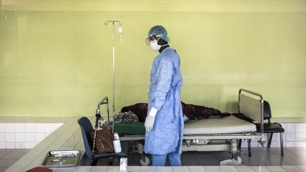 A Health worker tends to a patient inside a COVID-19 coronavirus ward that houses suspected cases in Pikine Hospital in Dakar on April 23, 2020. As COVID-19 coronavirus cases slowly increase in Senegal, hospitals are preparing to receive and test suspect cases whilst safely treating their normal patients. JOHN WESSELS / AFP