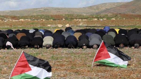 In this file photo taken on January 31, 2020 Palestinian protesters perform the Friday prayer behind national flags during a protest against a US brokered Middle East peace plan, outside the West Bank village of Tamun near the Jordan Valley, on January 31, 2020. Arab foreign ministers are to hold talks on April 30, 2020 on Israel's US-backed plans to annex key parts of the occupied West Bank. Concern has mounted since Israel's right-wing Prime Minister Benjamin Netanyahu -- an outspoken advocate of annexing