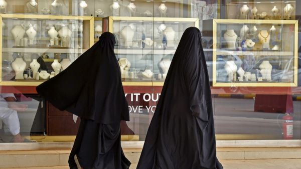 Saudi women walk past jewellers at the Tiba gold market in the capital Riyadh on April 30, 2020, after the partial lifting of the curfew. FAYEZ NURELDINE / AFP