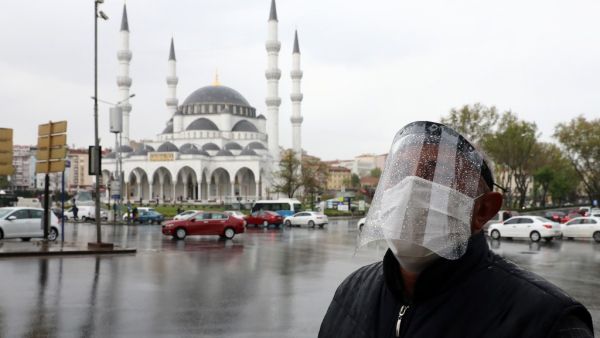 A man wearing a face-shield for protective measures crosses the streets as the spread of the COVID-19, the novel coronavirus continues in Ankara, on April 30, 2020. Adem ALTAN / AFP