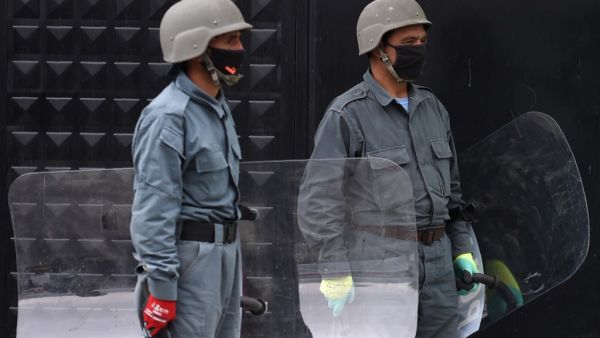 Afghan security personnel stand guard as civil society activists (not pictured) hold banners and shout slogans against the Iranian government during a protest in front of the Iranian embassy in Kabul on May 11, 2020. Afghanistan has recovered 18 bodies of migrants who were allegedly beaten and tortured before being forced into a river by Iranian border guards last week, a senior Afghan official said on May 8. Afghan authorities are investigating claims the migrants drowned while illegally crossing into neig