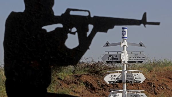 This picture taken on May 12, 2020 from a tourist lookout point at an Israeli army outpost on Mount Bental in the Israeli-annexed Golan Heights shows a directional sign for cities and places across the world and listing their respective distances. JALAA MAREY / AFP