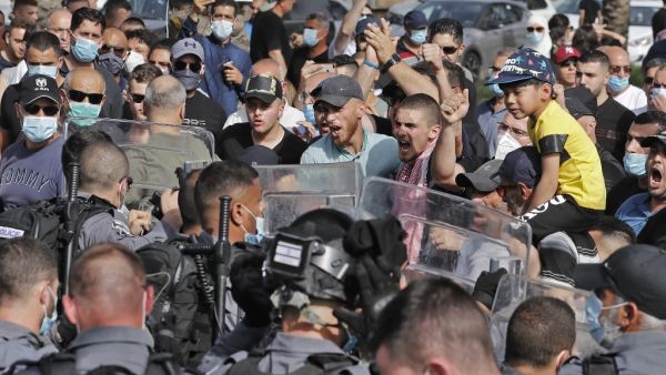 People chant slogans as they gather before Israeli security forces for a demonstration near the northern Arab Israeli city of Arara on May 14, 2020, after a man was shot to death after stabbing a security guard outside Tel Hashomer Hospital. Ahmad GHARABLI / AFP