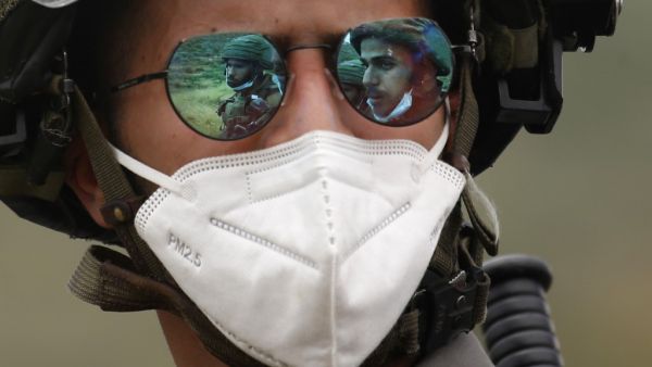 The images of two Israeli soldiers are projected on the sunglasses of a third one wearing a mask against the coronavirus Covid-19 during a protest by Palestinians against Israeli settlements on May 15, 2020 in al-Sawiya village, south of Nablus, in the occupied West Bank. JAAFAR ASHTIYEH / AFP