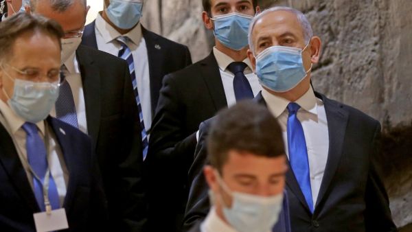 Israeli Prime Minister Benjamin Netanyahu (R), wearing a protective face mask, arrives for the swearing-in ceremony at Israel's parliament, the Knesset, in Jerusalem on May 17, 2020 As Israel was set to launch its new unity government Sunday, Prime Minister Benjamin Netanyahu vowed to push on with controversial plans to annex large parts of the occupied West Bank. POOL / AFP