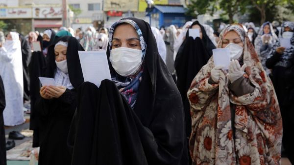 Muslim women worshippers, standing spaced from each other with some clad in masks as a measure against the COVID-19 coronavirus pandemic, as they gather to attend the prayers of Eid al-Fitr, the Muslim holiday which starts at the conclusion of the holy fasting month of Ramadan, in Iran's capital Tehran on May 24, 2020. (AFP)
