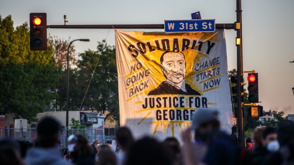 A banner depicting George Floyd is hanged to a street light during a demonstration to call for justice for George Floyd, a black man who died while in custody of the Minneapolis police, on May 30, 2020 in Minneapolis, Minnesota. (DELIL SOULEIMAN / AFP)
