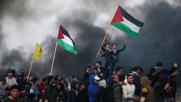 Palestinian protesters wave national flags during clashes with Israeli security forces on the eastern outskirts of Gaza City, near the border with Israel, on January 12, 2018. (AFP Photo/Mohammed Abed)