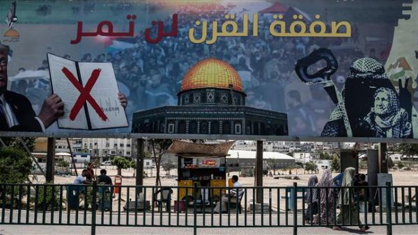 The picture taken on June 16, 2019, shows a poster in Gaza City denouncing US President Donald Trump's so-called peace plan, reading, "The deal of the century will not pass." (By AFP)