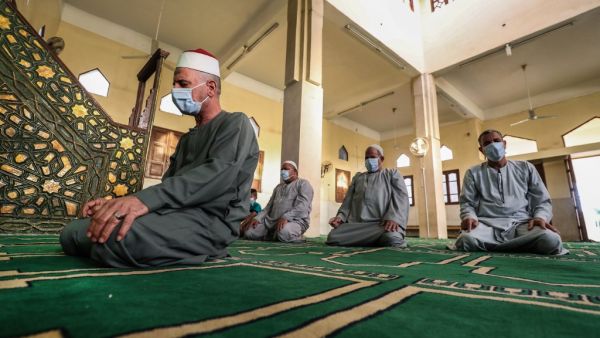 An Imam leads a handful of Muslim worshippers, all clad in masks due to the COVID-19 coronavirus pandemic, during the prayers of Eid al-Fitr, the Muslim holiday which starts at the conclusion of the holy fasting month of Ramadan, inside a mosque in the village of Shamma in Egypt's northern Nile delta province of Menoufia early on May 24, 2020. (AFP/File)