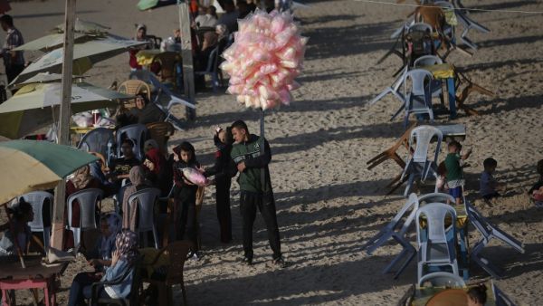 Palestinians gather at the beach during the Eid al-Fitr, the Muslim holiday which starts at the conclusion of the holy fasting month of Ramadan, in Gaza City on May 26, 2020 amid the coronavirus Covid-19 pandemic. Local authorities in the Hamas-run Palestinian enclave allowed mosques to reopen for Eid al-Fitr as social distancing procedures for the novel coronavirus are maintained while encouraging the elderly to perform prayers from home. MAHMUD HAMS / AFP