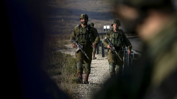 Israeli soldiers stand guard near the scene of a reported car-ramming attack north of the city of Ramallah in the Israeli-occupied West Bank, on May 29, 2020. A Palestinian man tried to ram a car into Israeli soldiers in the West Bank before being shot dead by troops, the Israeli army said in a statement. ABBAS MOMANI / AFP