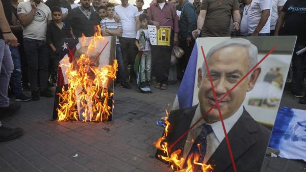 Palestinian demonstrators burn pictures of US President Donald Trump and Israeli Prime Minister Benjamin Netanyahu during a demonstration against the plans to annex parts of the occupied West Bank on May 30, 2020, in Nablus in the occupied West Bank. JAAFAR ASHTIYEH / AFP