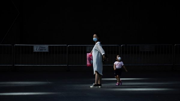 A woman and a child wearing face mask walk out of a mall in Beijing on June 2, 2020. WANG ZHAO / AFP