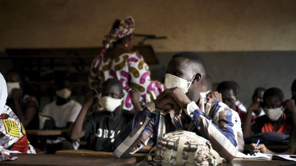 A Malian pupil wears a face mask in the classroom of a school as the government decided to resume lessons after two months of closure due to the spread of COVID-19 coronavirus, in Bamako on June 2, 2020. All the students have been provided with masks to wear mandatorily and the lessons have been reorganised in order to have a maximum number of 25 students per classroom. MICHELE CATTANI / AFP