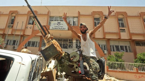A fighter loyal to Libya's UN-recognised Government of National Accord (GNA) poses for a picture while seated in the turret a technical (pickup truck mounted with turret) in the town of Tarhuna, about 65 kilometres southeast of the capital Tripoli on June 5, 2020, after the area was taken over by pro-GNA forces from rival forces loyal to strongman Khalifa Haftar. The GNA said on June 5 that it was back in full control of Tarhouna, the last stronghold of the forces of eastern strongman Khalifa Haftar. The UN