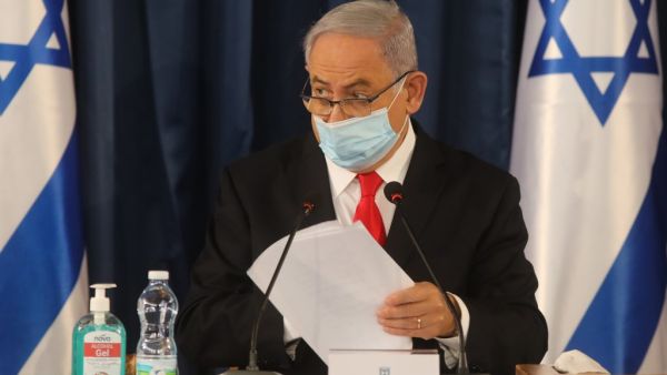 Israeli Prime Minister Benjamin Netanyahu, wearing a protective mask due to the COVID-19 pandemic, chairs the weekly cabinet meeting in Jerusalem on June 7, 2020. Netanyahu urged world powers to reimpose tough sanctions against Iran, vowing to curb Tehran's regional "aggression" hours after another deadly strike on pro-Iranian fighters in Syria. Menahem KAHANA / AFP