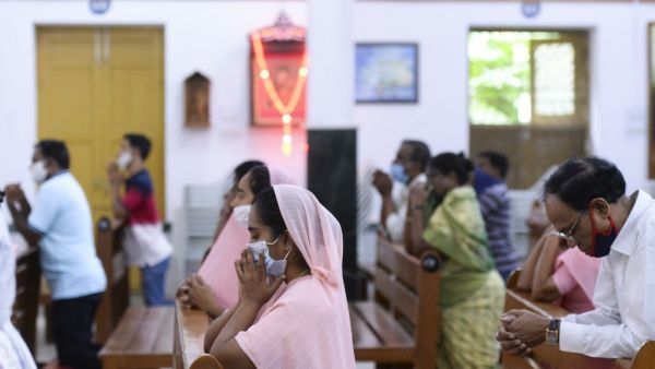 Catholic devotees wear face mask attend the Holy Mass at the Saint Joseph's Church on the first day after the reopening of religious services after the government eased restrictions imposed as a preventive measure against the COVID-19 coronavirus, in Hyderabad on June 8, 2020. NOAH SEELAM / AFP
