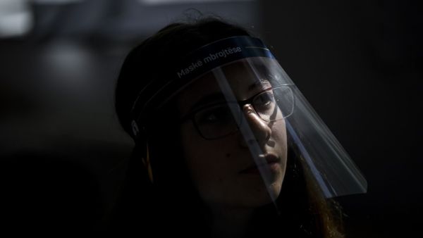 A student wearing a 3D printed face shield and gloves attends a class at the "Faik Konica" primary school in Pristina on June 9, 2020, as the schools in Kosovo gradually reopen, after almost three months of restrictions due to the risk of Covid-19 pandemic caused by the novel coronavirus. Armend NIMANI/AFP Armend NIMANI / AFP