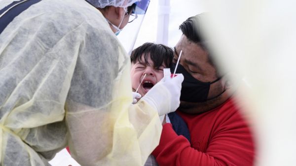 In this file photo Jose Vatres (R) holds his son Aidin who reacts as nurse practitioner Alexander Panis (L) takes a nasal swab sample to test for COVID-19 at a mobile testing station in a public school parking area in Compton, California, just south of Los Angeles, on April 28, 2020. June 10, 2020 the number of confirmed coronavirus infections in the United States topped two million according to a tally by Johns Hopkins University. The pandemic has claimed the lives of more than 112,900 people in the United