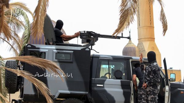 Members of security forces affiliated with the Libyan Government of National Accord (GNA)'s Interior Ministry stand at a make-shift checkpoint in the town of Tarhuna, about 65 kilometres southeast of the capital Tripoli on June 11, 2020. Mahmud TURKIA / AFP