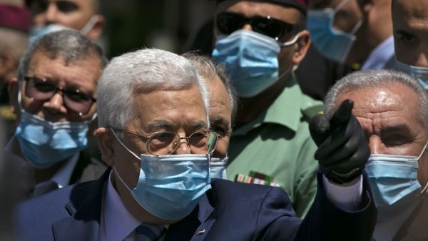 Palestinian President Mahmud Abbas calls on people to wear protective masks as he walks in a street in the West Bank city of Ramallah on June 15, 2020. ABBAS MOMANI / AFP