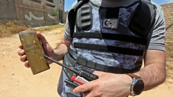 A Turkish deminer holds the remains of en explosive device in the Salah al-Din area, south of the Libyan capital Tripoli, on June 15, 2020. Human Rights Watch earlier this month accused pro-Haftar forces of laying Russian and Soviet-era landmines as they withdrew from Tripoli's southern districts. A team of Turkish deminers arrived in Tripoli last week to bring their expertise, under a broader military cooperation agreement signed late last year between Tripoli and Ankara. Mahmud TURKIA / AFP