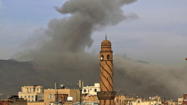 In this file photo taken on June 16, 2020, smoke billows following an airstrike by Saudi-led coalition in the Yemeni capital Sanaa. On top of war and the coronavirus pandemic, Yemen faces looming economic disaster as a crisis gripping its main benefactor Saudi Arabia dents remittances and leaves state coffers running dry. MOHAMMED HUWAIS / AFP