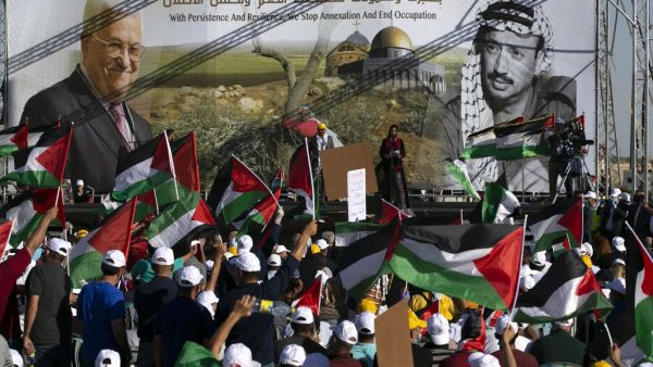 Palestinians wave flags during a big rally called by Palestinian Authority's Fatah party to protest against Israel's plan to annex parts of the occupied West Bank, in Jericho on June 22, 2020. Israel intends to annex West Bank settlements and the Jordan Valley, as proposed by US President Donald Trump, with initial steps slated to begin from July 1. ABBAS MOMANI / AFP