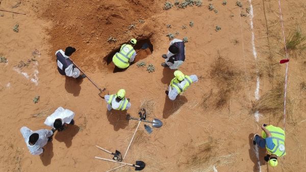An aerial view shows Libyan experts searching for human remains during the exhumation of mass graves in Tarhuna, southeast of the capital Tripoli, on June 23, 2020. (AFP)
