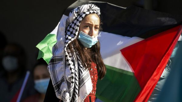 A Palestinian youth wearing a protective mask amid the COVID-19 pandemic takes part in a a rally against Israel's West Bank annexation plans, in the Jordan Valley village of Bardala in the occupied Palestinian territory, on June 27, 2020. JAAFAR ASHTIYEH / AFP
