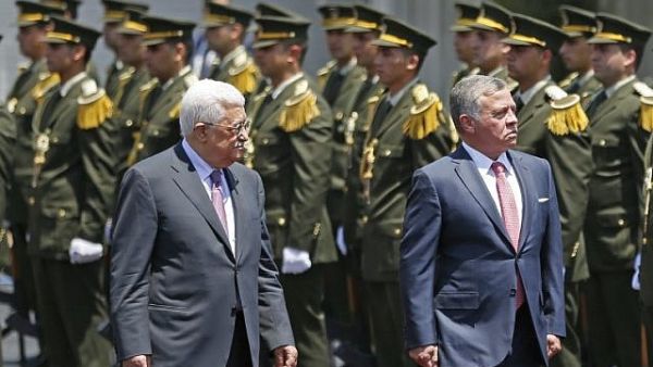 Jordan's King Abdullah II and Palestinian Authority President Mahmoud Abbas observe the honor guard during a visit in the West Bank city of Ramallah on August 7, 2017. (AFP PHOTO / ABBAS MOMANI)