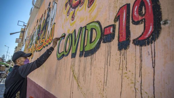A Moroccan artist works on a mural thanking essential workers amid the COVID-19 pandemic, in the city of Sale north of the capital. (File/AFP)