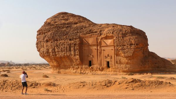 A tourist photographs Area C tombs at Madain Saleh Heritage Site. (Shutterstock/ File Photo)
