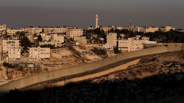 This picture taken on June 30, 2020 shows a view of Israel's controversial separation barrier between the West Bank city of Abu Dis (background) and East Jerusalem (foreground). AHMAD GHARABLI / AFP