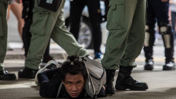 Riot police detain a man as they clear protesters taking part in a rally against a new national security law in Hong Kong on July 1, 2020, on the 23rd anniversary of the city's handover from Britain to China. Hong Kong police made the first arrests under Beijing's new national security law on July 1 as the city greeted the anniversary of its handover to China with protesters fleeing water cannon. DALE DE LA REY / AFP