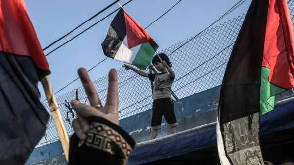 A Palestinian boy waves a national flag during a demonstration against Israel's West Bank annexation plans, in Khan Yunis in the southern Gaza Strip on July 2, 2020. SAID KHATIB / AFP