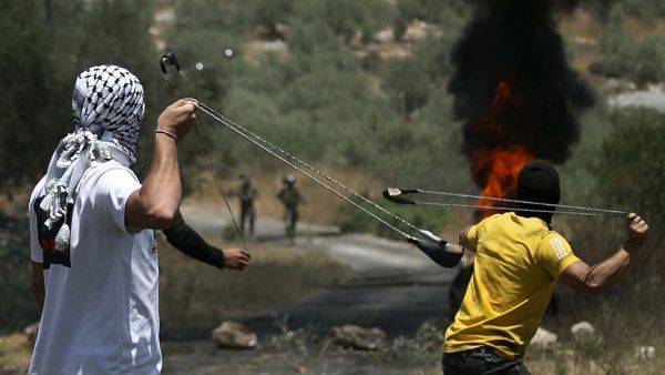 Palestinian protesters use slingshots to hurl stones towards Israeli forces during a demonstration in the village of Kfar Qaddum in the occupied West Bank against the Jewish state's plans to annex part of the Palestinian territory on July 3, 2020. Rival Palestinian factions Fatah and Hamas pledged the previous day a united campaign against Israel's prospective plans to annex territory in the occupied West Bank, in a rare joint press conference, spurred by their common opposition to US President Donald Trump