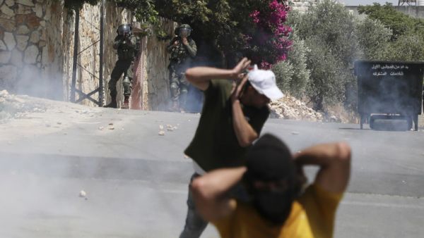 Palestinian protesters run for cover as Israeli troops fire tear gas towards the crowd during a demonstration in the village of Kfar Qaddum in the occupied West Bank against the Jewish state's plans to annex part of the Palestinian territory on July 3, 2020. Rival Palestinian factions Fatah and Hamas pledged the previous day a united campaign against Israel's prospective plans to annex territory in the occupied West Bank, in a rare joint press conference, spurred by their common opposition to US President D