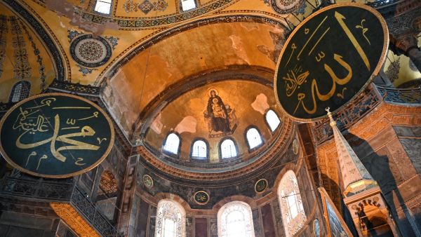 This file photograph taken on July 2, 2020, shows the Virgin Mary and child fresco and a calligraphic Roundels with Arabic letters bearing the name of Allah and other Muslim prophets hanging on the dome of The Hagia Sophia Museum in Istanbul. (AFP/File)