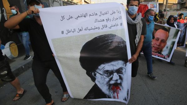Iraqi demonstrators attend a symbolic funeral for slain Iraqi jihadism expert Hisham al-Hashemi, who was shot dead yesterday outside his house in the Iraqi capital, on July 7, 2020 at Baghdad's Tahrir square. Slogan reads in Arabic: "in response to the killing of Hashem al Hashemi, all free are to use the hashtag "Khamenei (Iran's Supreme Leader Ayatollah Ali Khamenei) is a killer and his militias are wrongdoers". (AHMAD AL-RUBAYE / AFP)
