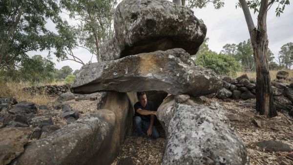 Uri Berger, a regional archaeologist for the Israel Antiquities Authority, sits inside a dolmen from the intermediate Bronze age, in the Israeli-annexed Golan Heights on July 13, 2020. This megalithic structure is one of the thousands of dolmens scattered around northern Israel and the region, burial tombs erected some 4000-4500 years ago in the Intermediate Bronze Era. MENAHEM KAHANA / AFP