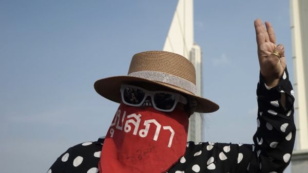 A protester makes the three-fingered Hunger Games salute while taking part in an anti-government demonstration in Bangkok on July 18, 2020. Scuffles broke out as thousands of mainly young and black-clad Thai protesters converged on July 18 at Bangkok's Democracy Monument, in the city's rowdiest anti-government protest in years. Aidan JONES / AFP