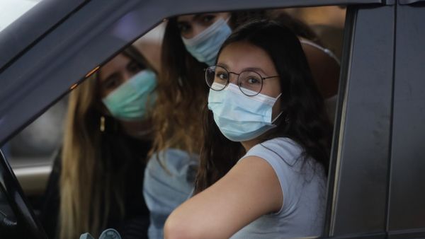 Lebanese women wearing protective masks amid the COVID-19 pandemic wait in their car to watch a movie at a drive-in cinema at a park in the coastal town of Byblos, north of the capital on July 18, 2020. A group of Lebanese university graduates launched a drive-in cinema, as movie theatres remain closed due to the novel coronavirus pandemic. The income of the drive-in cinema will go to needy families to help deal with the country's economic crisis. JOSEPH EID / AFP