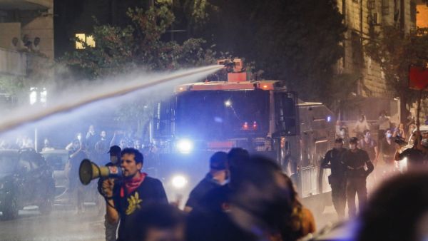 Israeli police spray protesters (clad in masks due to the COVID-19 coronavirus pandemic) with water cannon during an anti-government demonstration in Jerusalem, on July 18, 2020. Ahmad GHARABLI / AFP