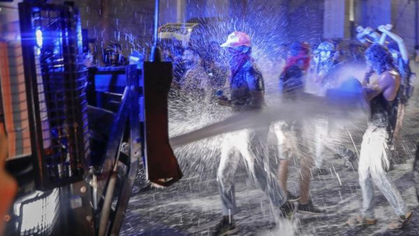 Israeli police spray protesters (clad in masks due to the COVID-19 coronavirus pandemic) with water cannon during a rally against Prime Minister Benjamin Netanyahu in Jerusalem, on July 19, 2020. Israeli police fired water cannons to disperse anti-government protests attended by thousands on Saturday, as public anger mounts over the handling of the coronavirus crisis. Demonstrators gathered outside Prime Minister Benjamin Netanyahu's residence in Jerusalem and at a park in Tel Aviv, voicing frustration over