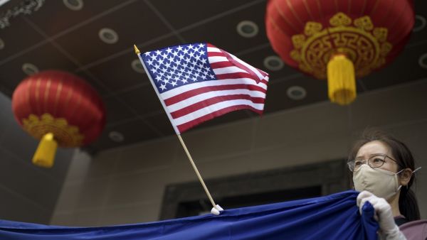 A protester holds a US flag outside of the Chinese consulate in Houston on July 24, 2020, after the US State Department ordered China to close the consulate. The US ordered China to close its Houston consulate, Beijing said on July 22, in what it called a "political provocation" that will further harm diplomatic relations. Mark Felix / AFP