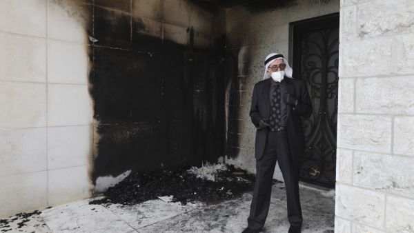 A Palestinian man stands at the entrance of a mosque that was torched and sprayed with graffiti in Hebrew, in Al-Bireh, north of the city of Ramallah in the Israeli-occupied West Bank on July 27, 2020. A mosque in the Israeli-occupied West Bank town of Al-Bireh was defaced by fire damage and Hebrew-language graffiti before dawn today, an attack blamed by Palestinians on Jewish settlers. ABBAS MOMANI / AFP