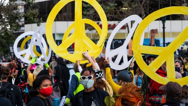 Protesters hold peace signs in support of Black Lives Matter on July 25, 2020 in Oakland, California. Demonstrators in Oakland gathered to protest in solidarity with Portland protests. Natasha Moustache/Getty Images/AFP
