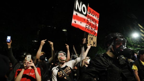 People gather in protest in front of the Mark O. Hatfield federal courthouse in downtown Portland as the city experiences another night of unrest on July 26, 2020 in Portland, Oregon. SPENCER PLATT / GETTY IMAGES NORTH AMERICA / Getty Images via AFP